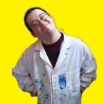 Smiling artist in paint covered smock